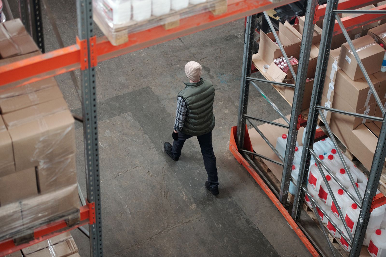 Medewerker loopt door een magazijn met voorraad en pakketten