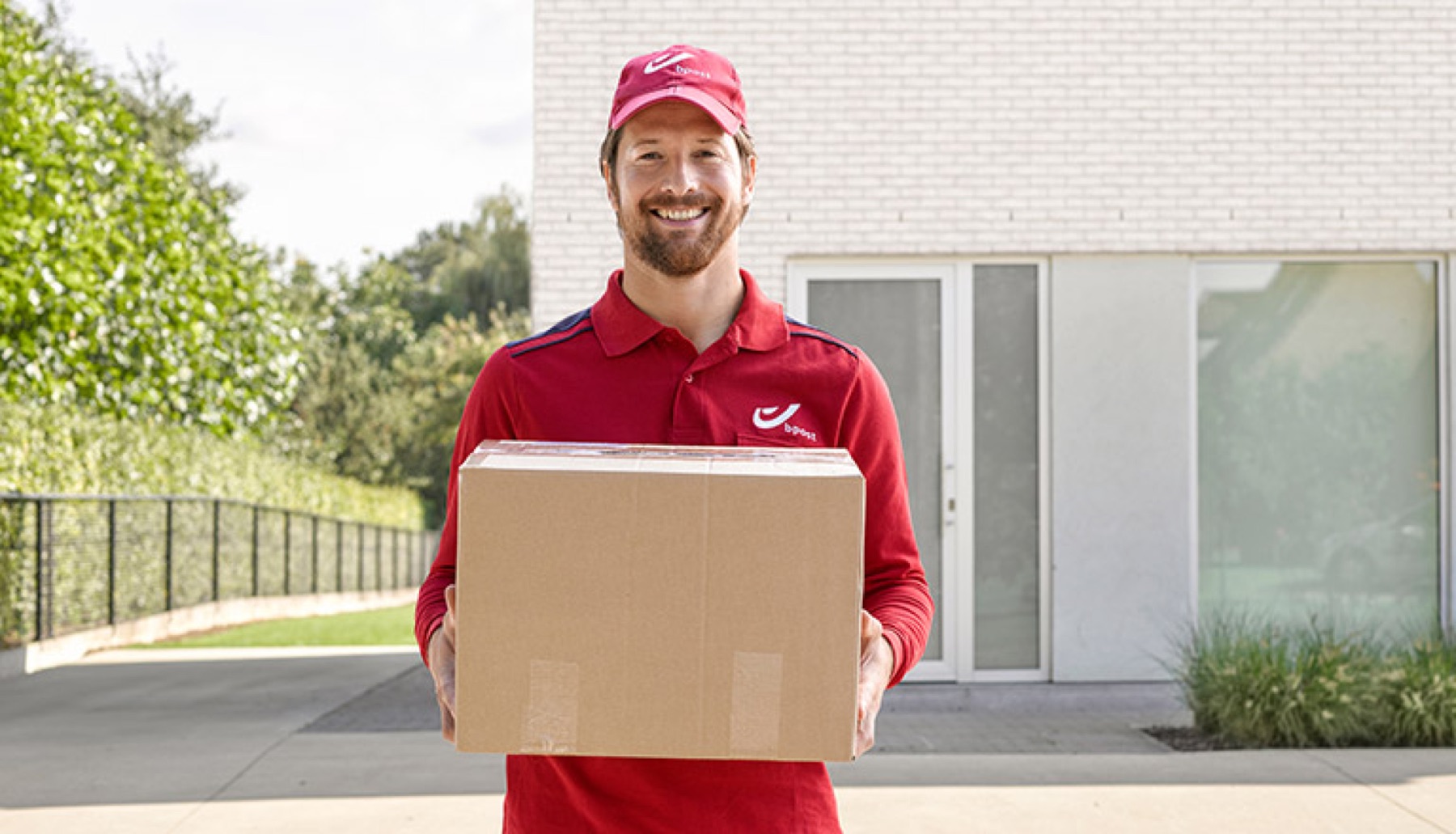 bpost-bezorger met een pakket bij een woning
